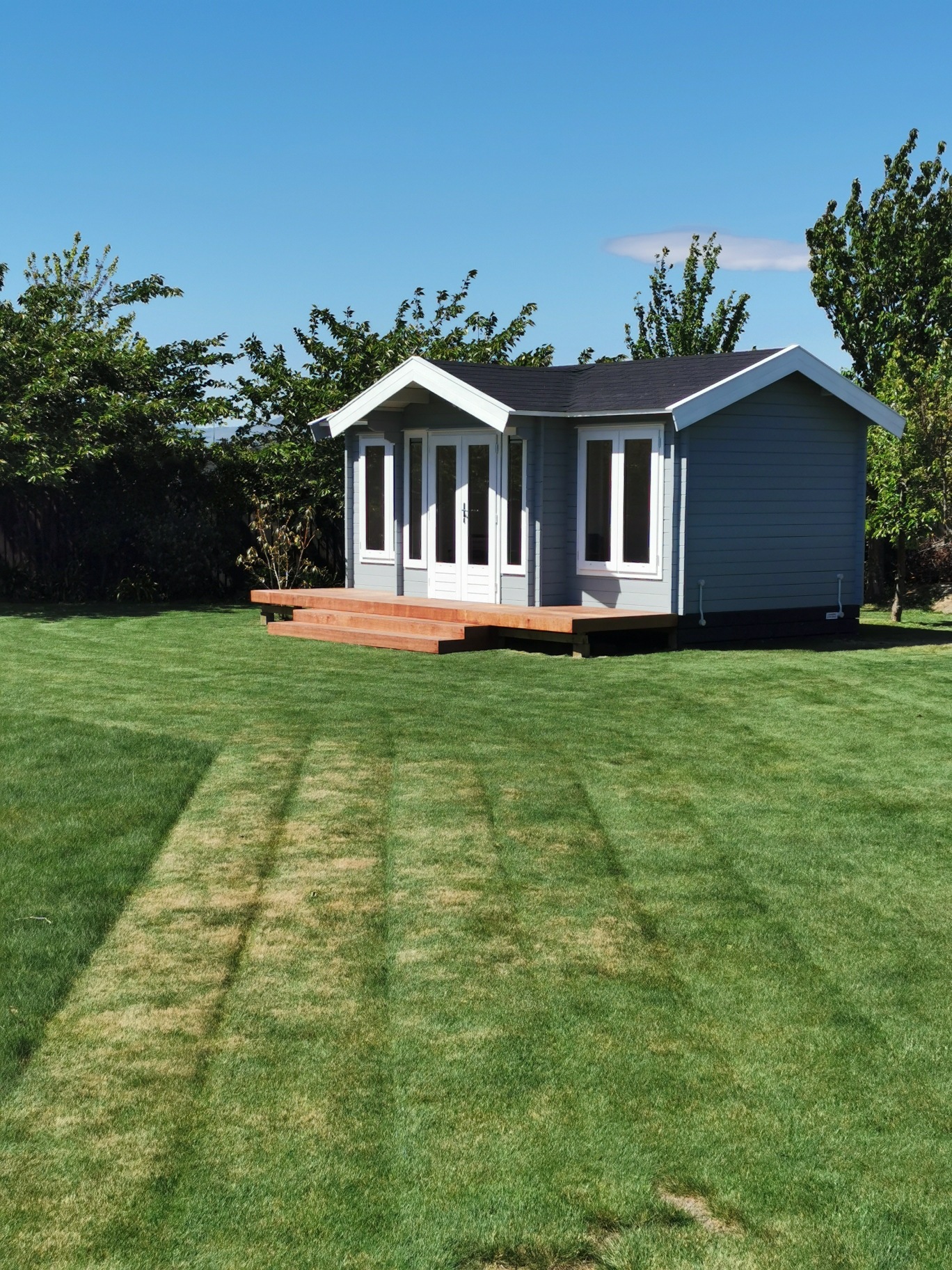 outside of painted brook river cabin used as backyard retreat with custom deck